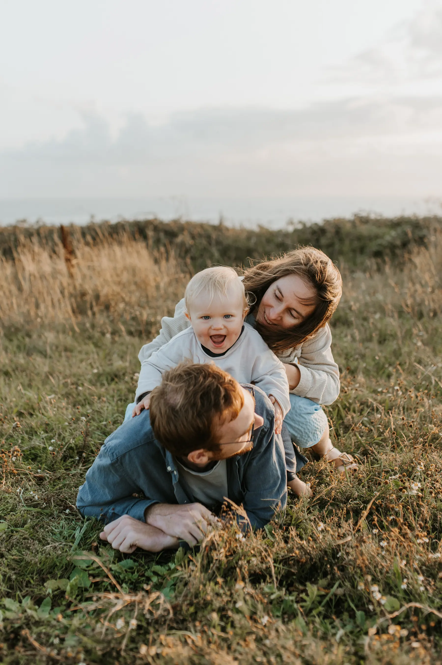 Une famille allongée dans l’herbe.