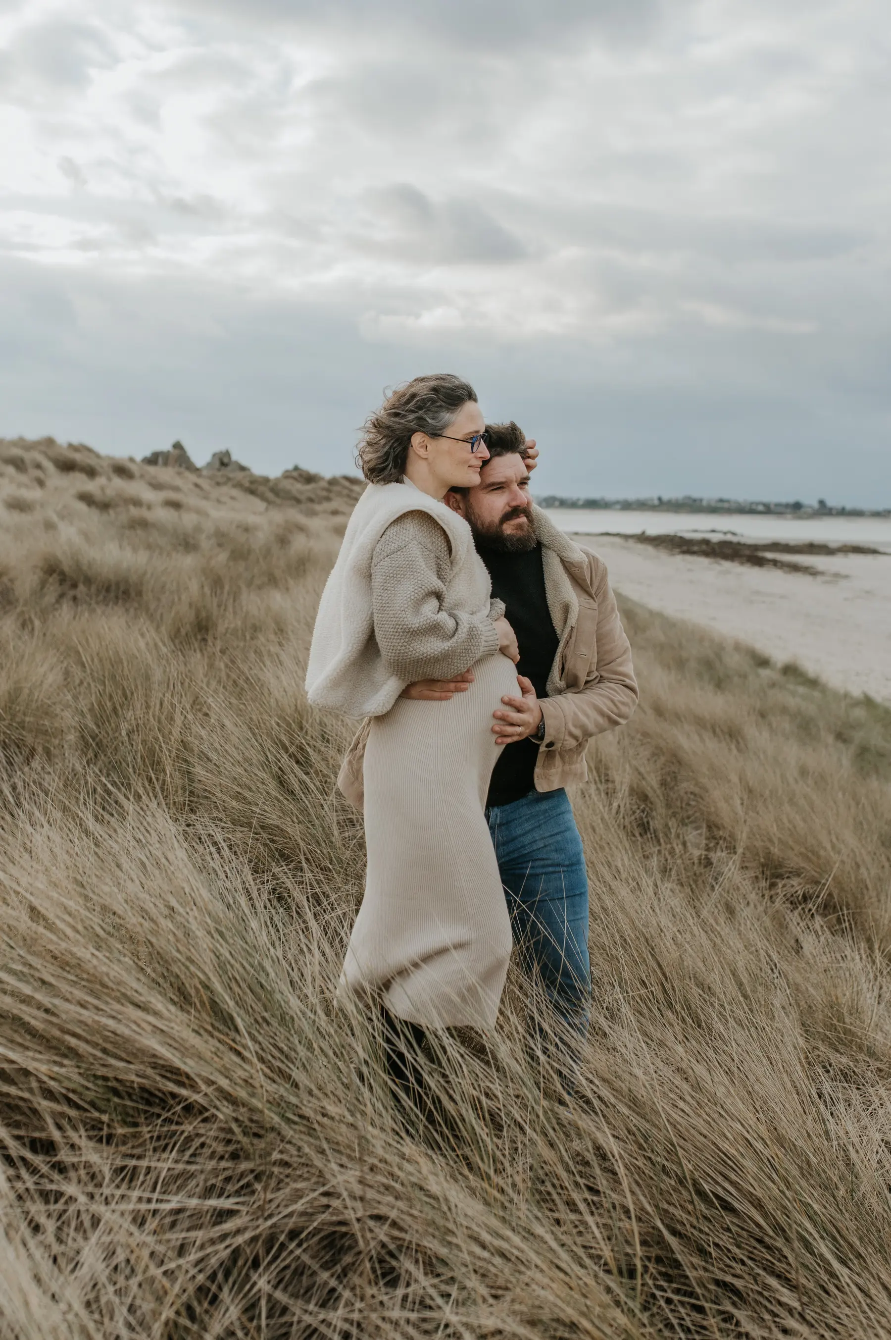 Un couple enlacé dans les dunes.
