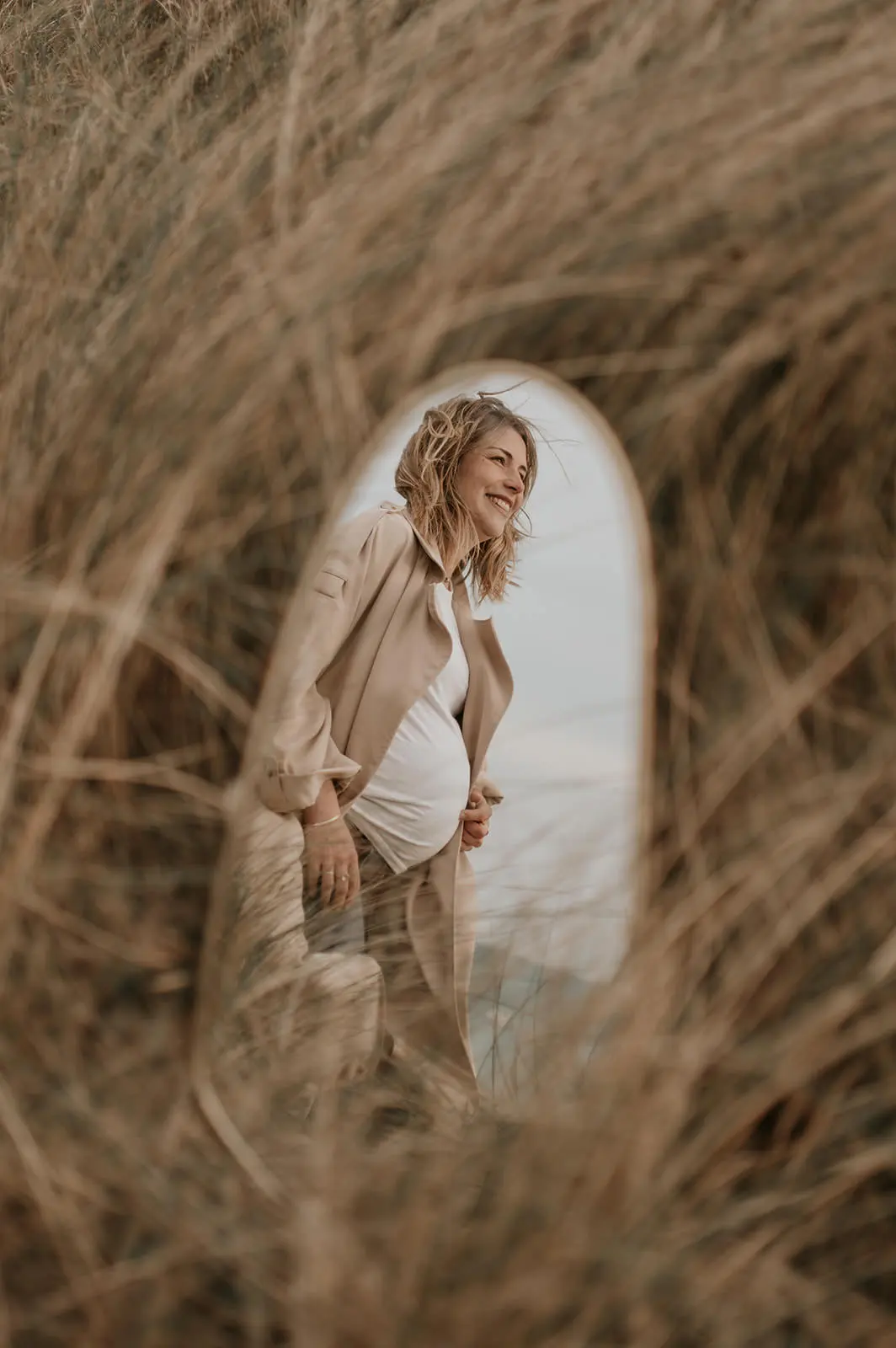 Une femme enceinte aperçue derrière les herbes hautes.