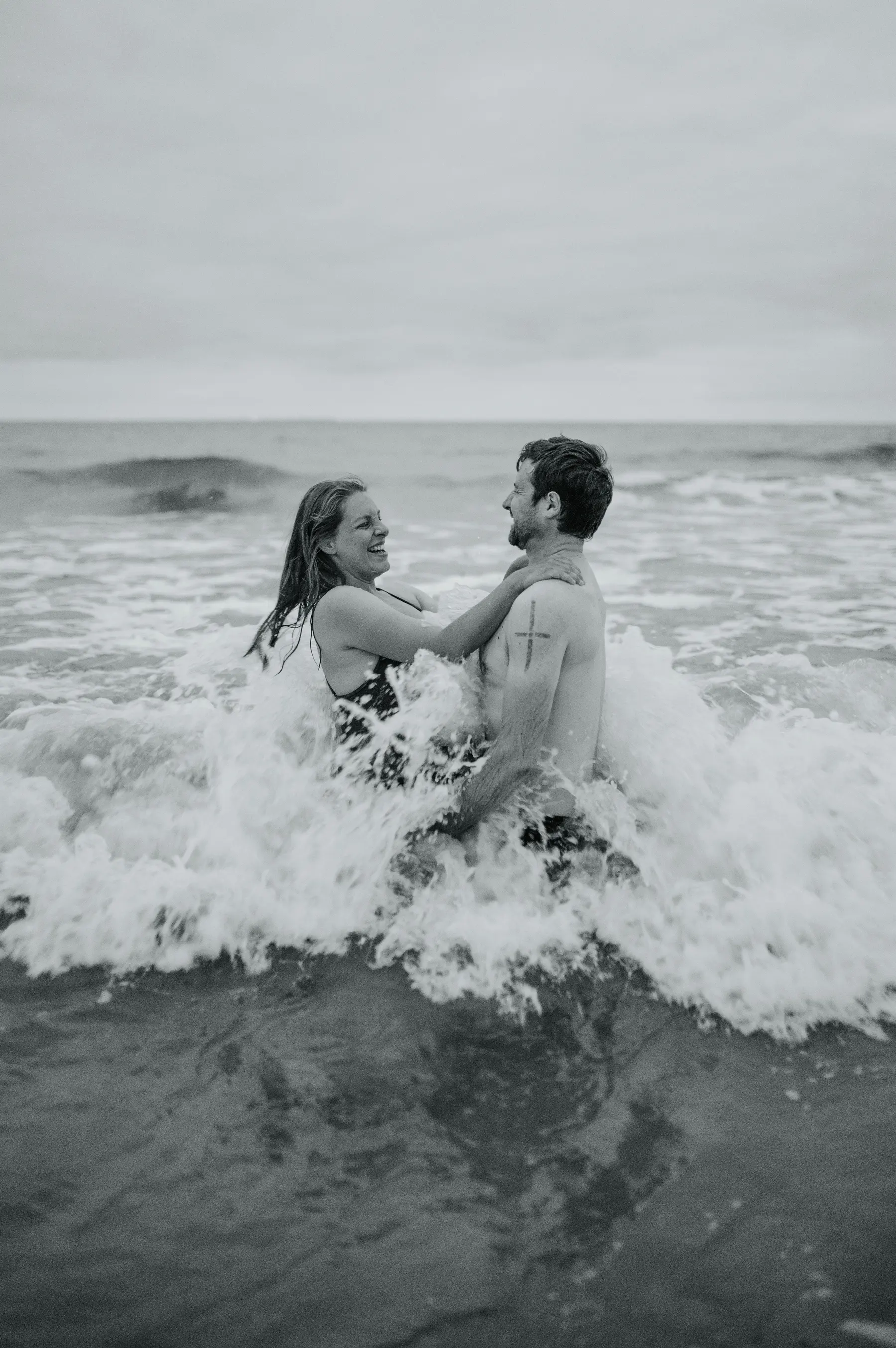 Un couple joue dans les vagues.