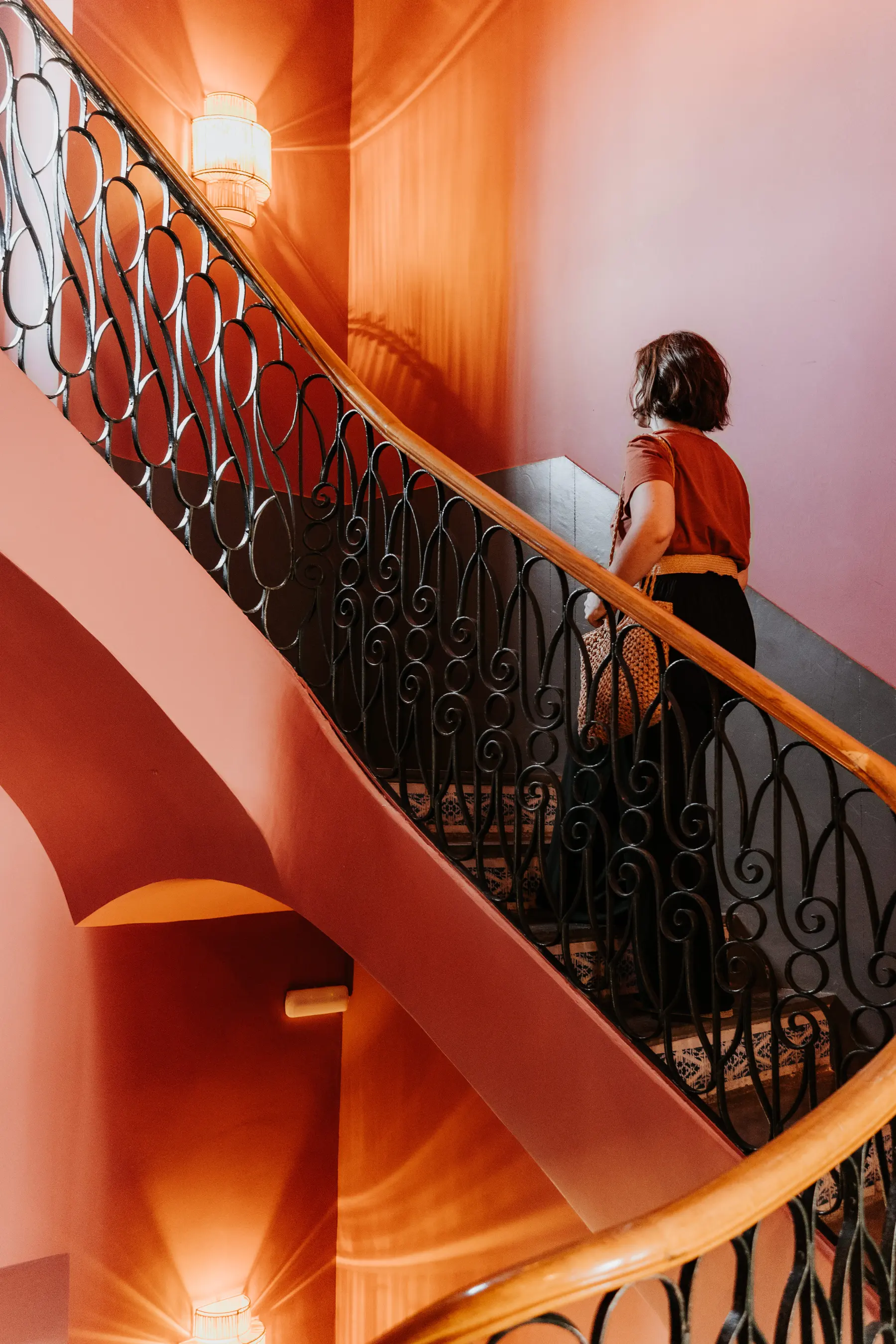 Une femme descend un escalier de fer forgé.