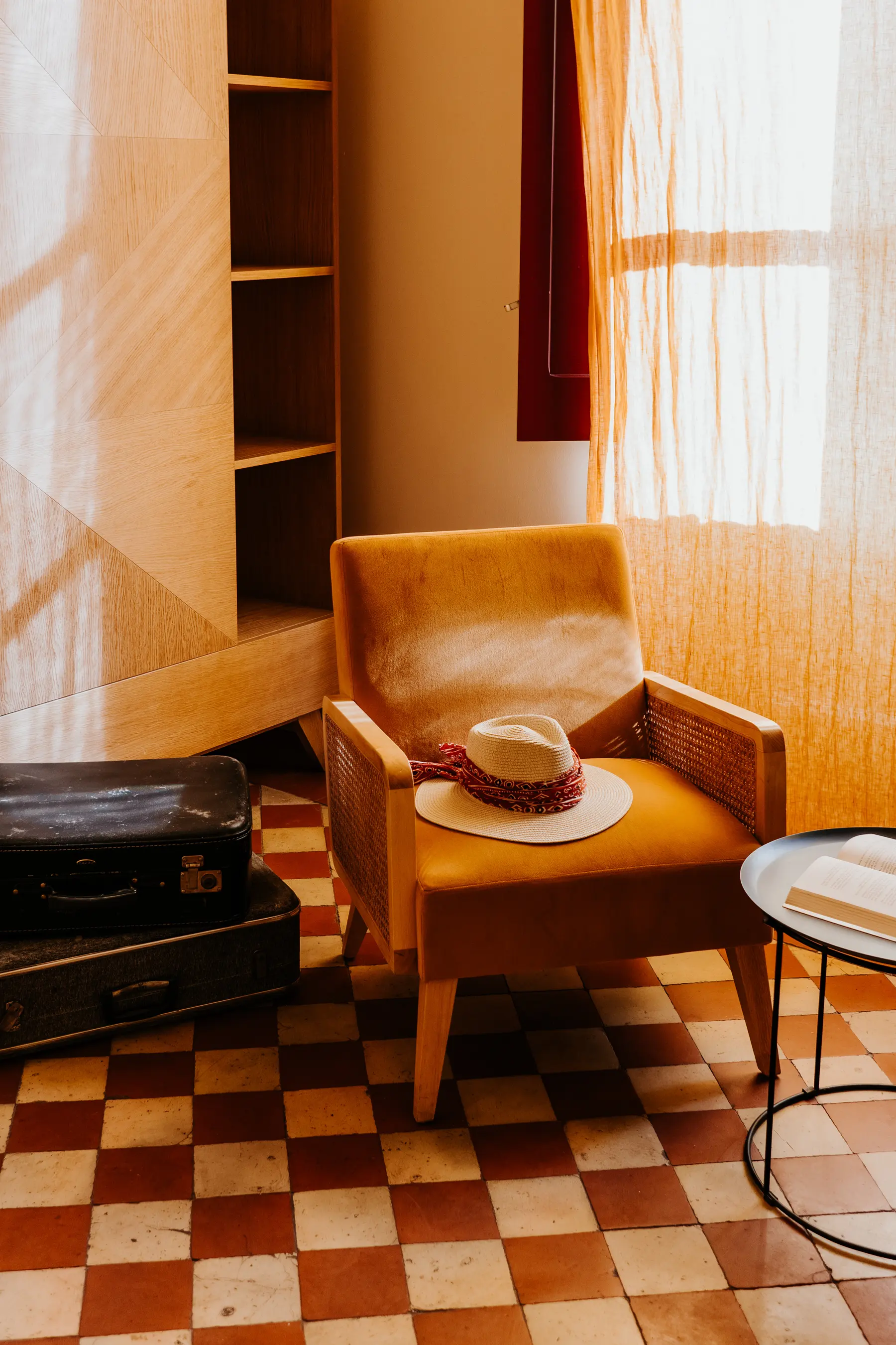 Un fauteuil orange posé sur un sol en damier.