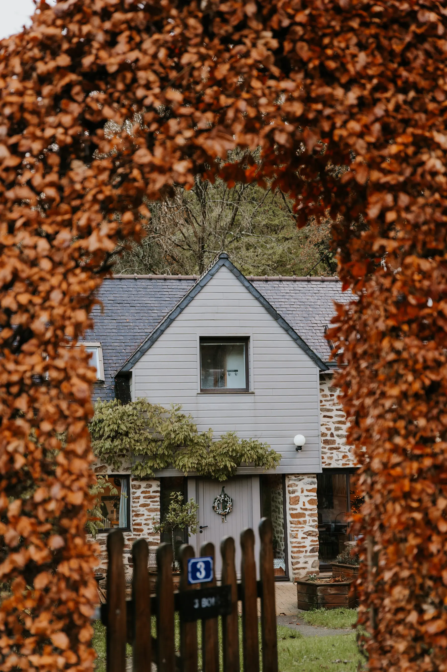 Une maison bretonne encadrée de feuillages roux d’automne.