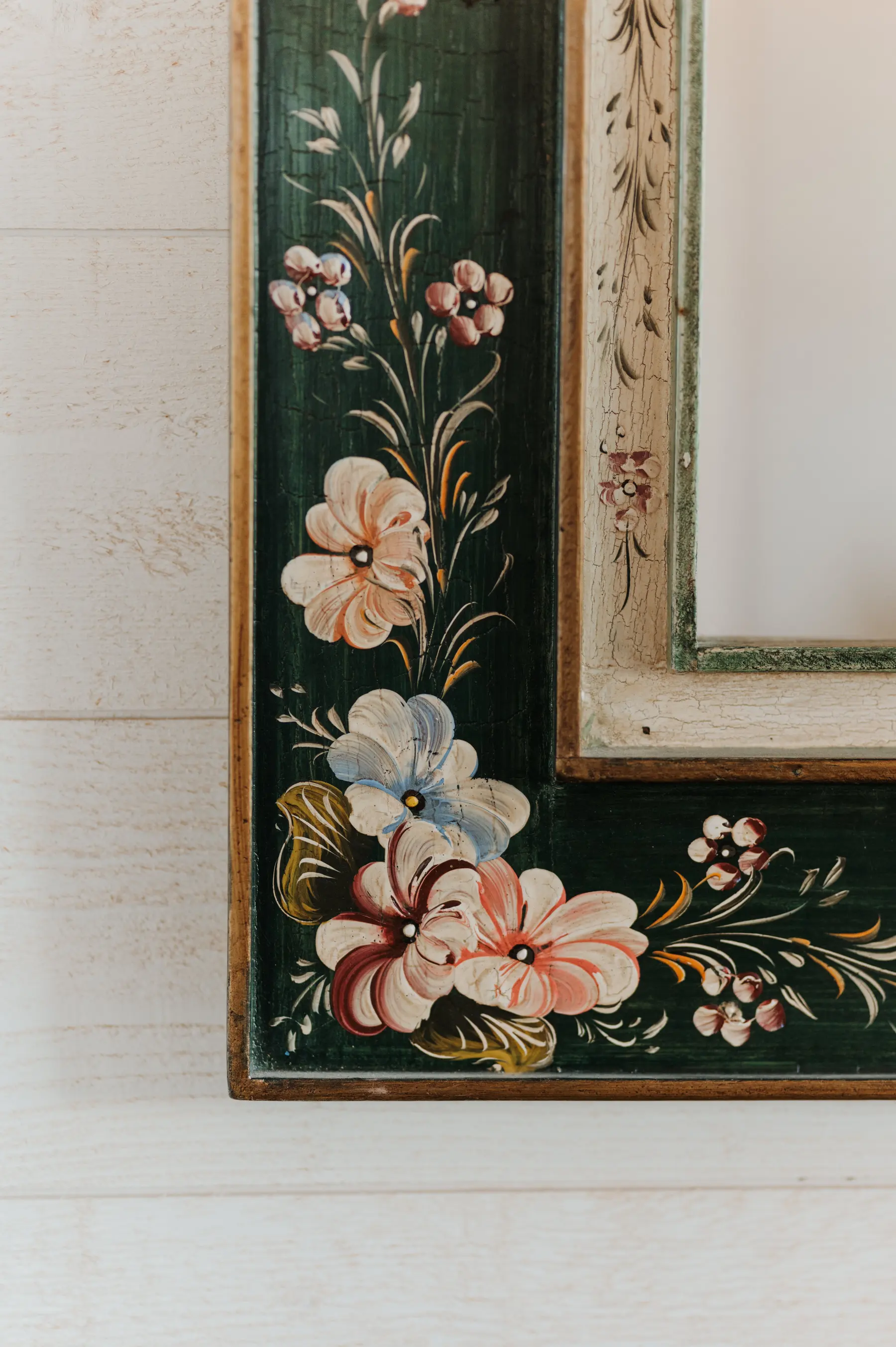 Un miroir ancien peint de motifs floraux.