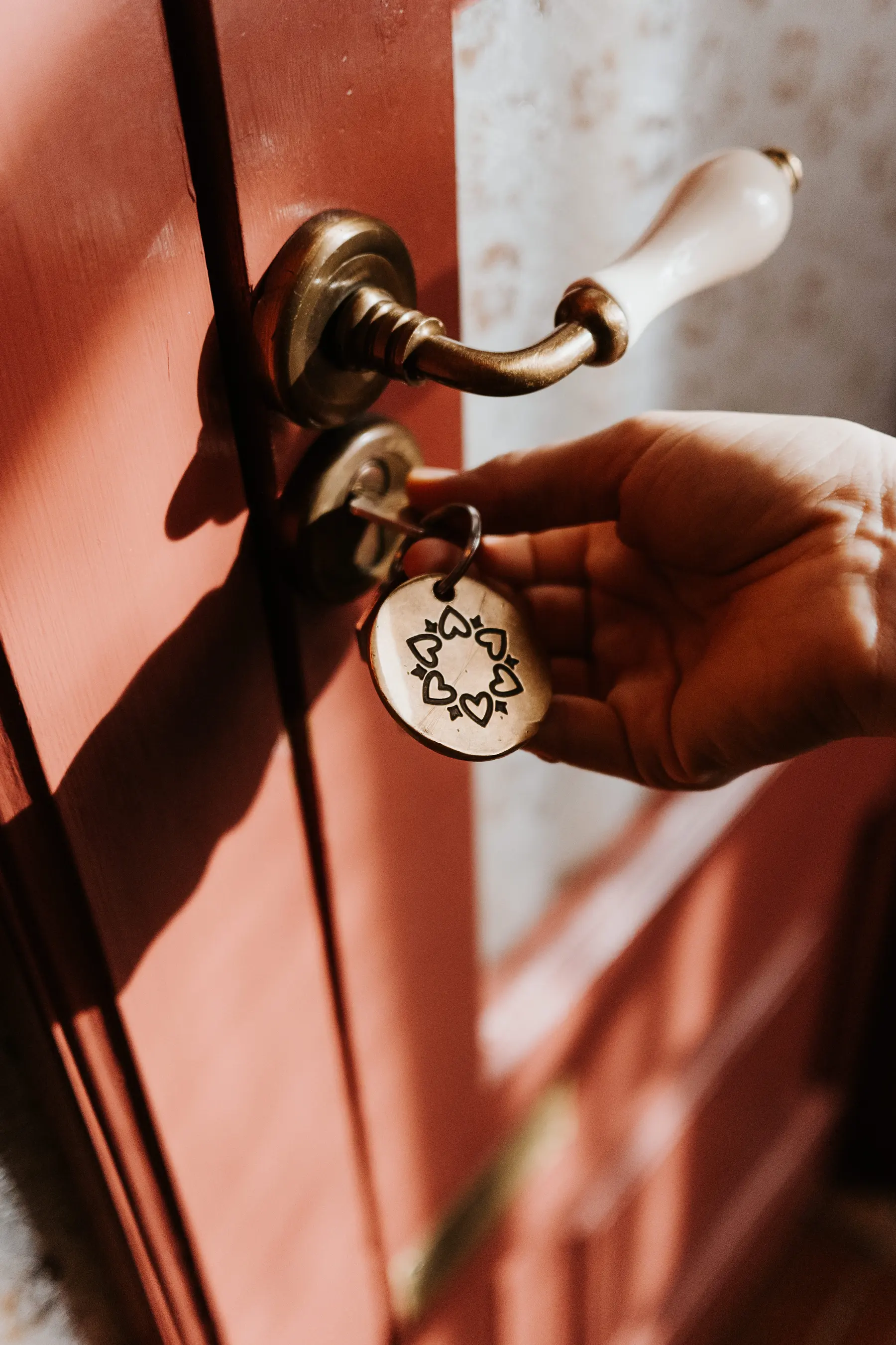 Une main pousse une porte rouge.