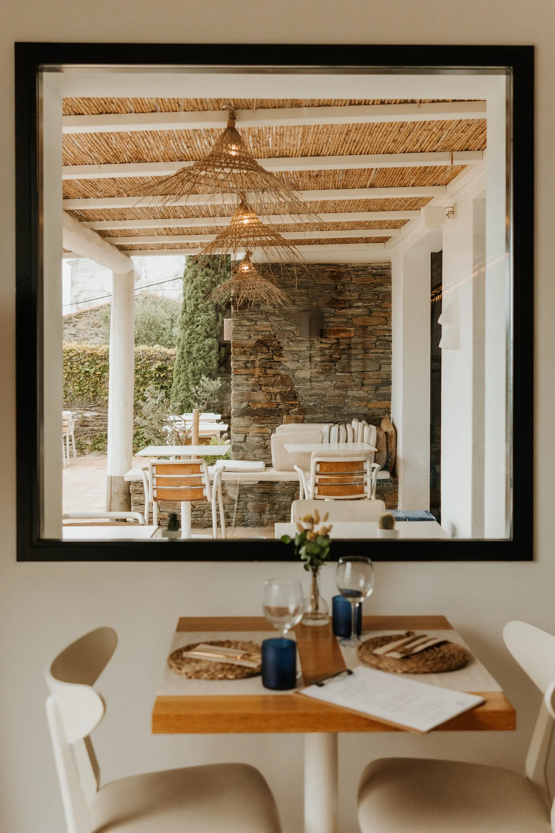 Une salle à manger dressée, reflétée dans un grand miroir.