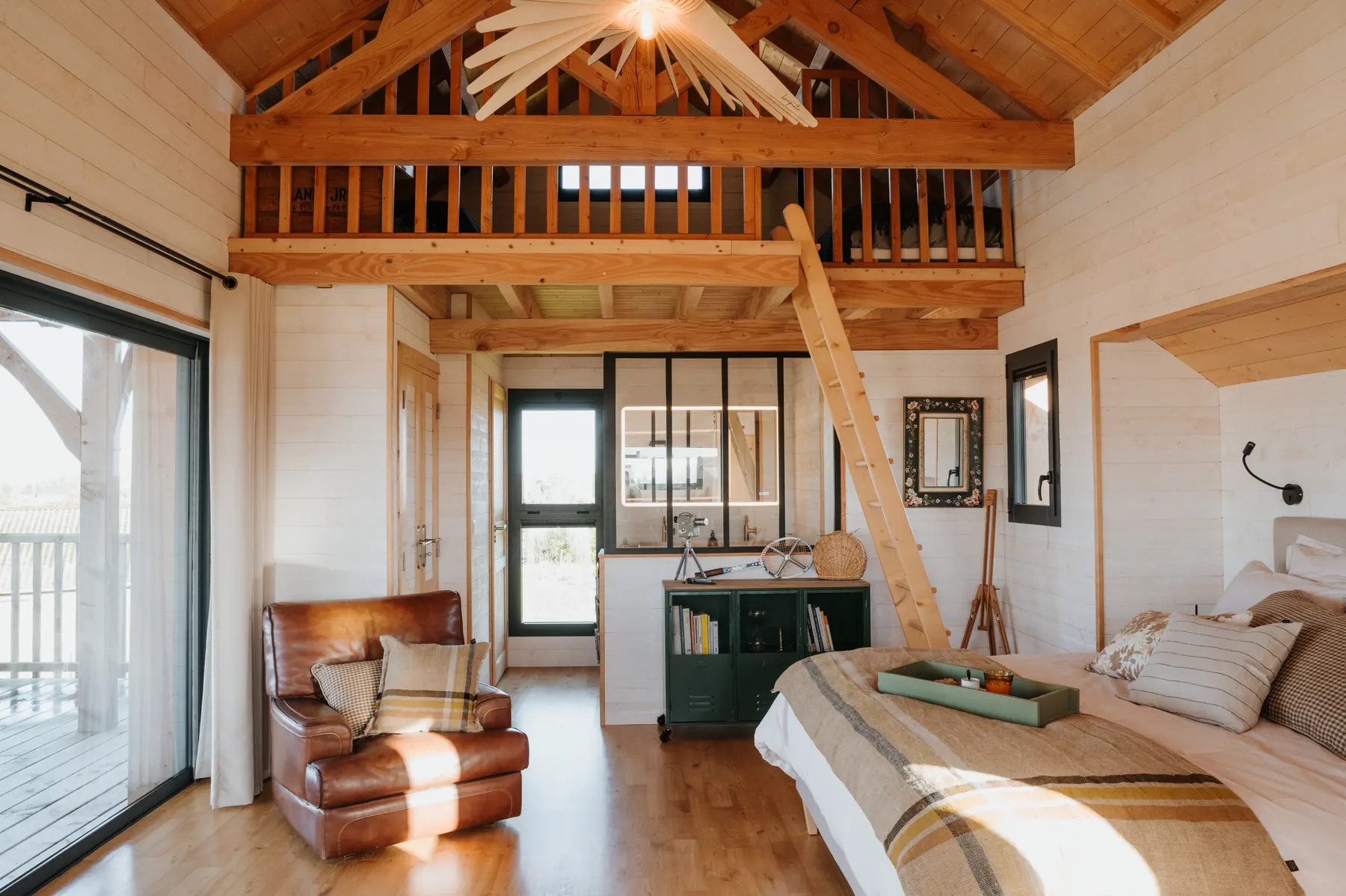 Un salon sous mezzanine de bois, dans un gîte contemporain breton.