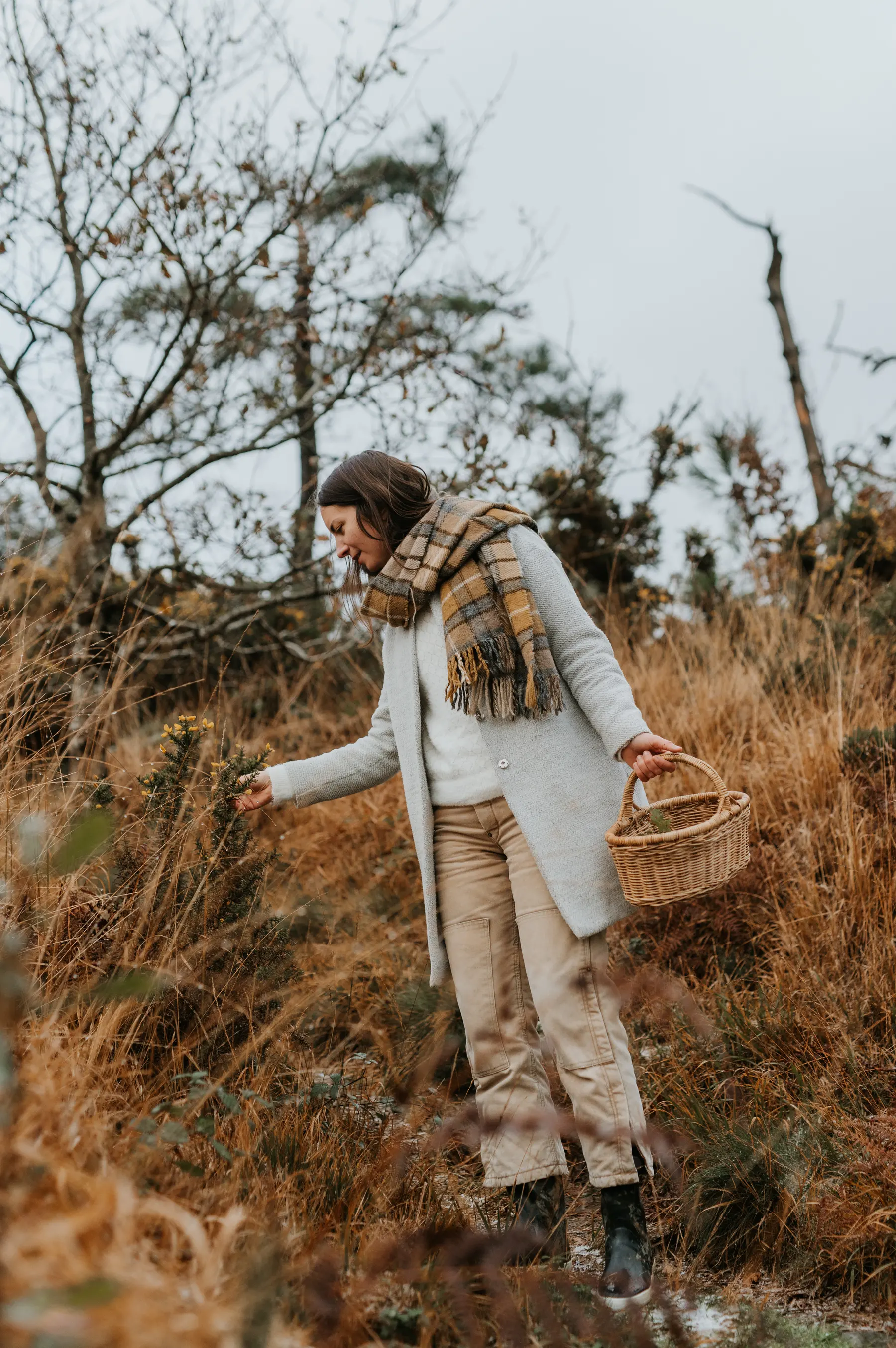 Une femme traverse la lande, un panier au bras.