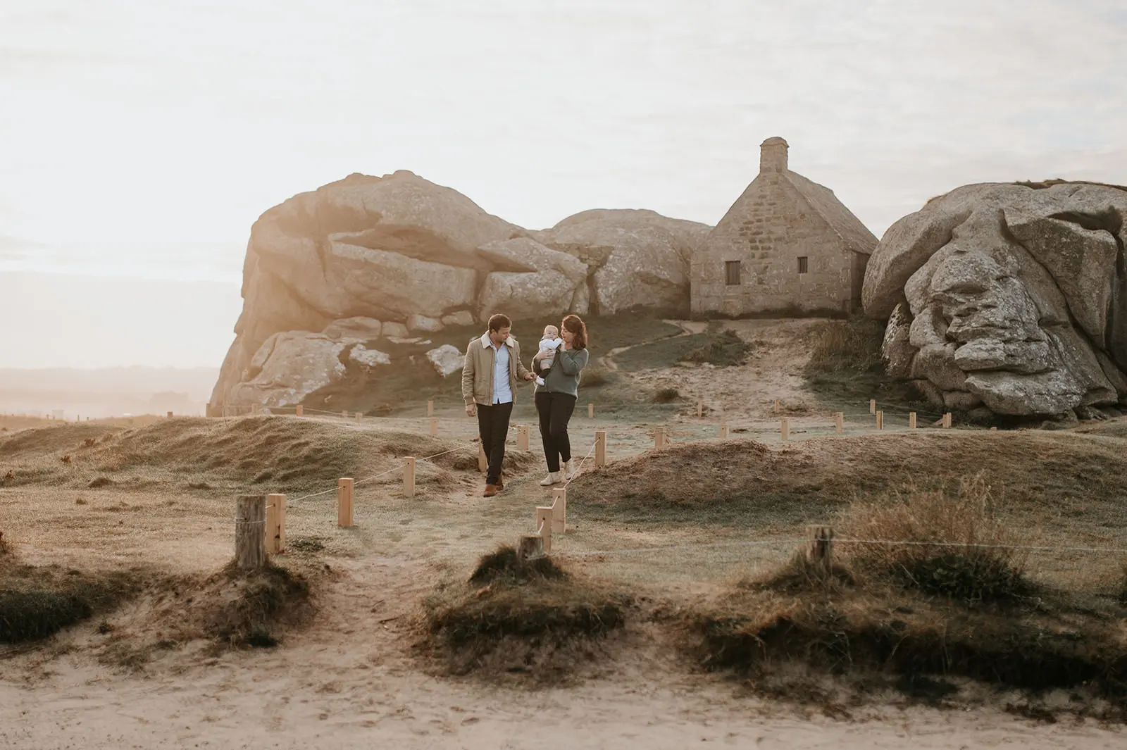 Une famille devant une chapelle, au milieu des dunes.
