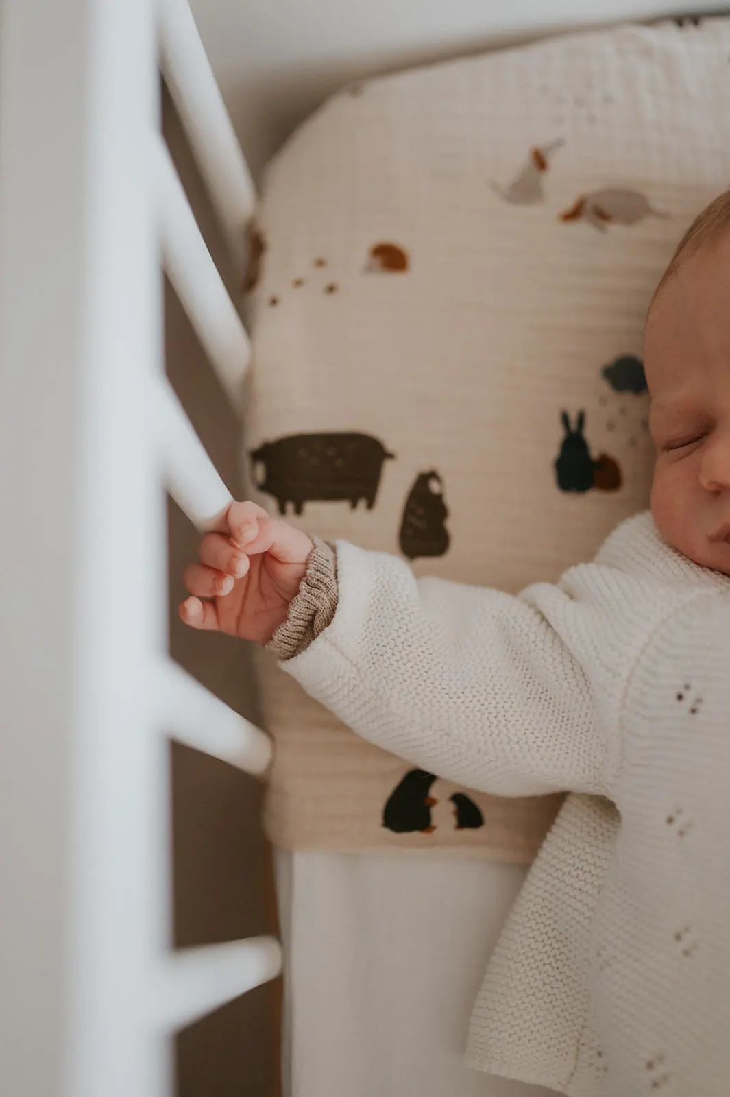 Un bébé debout dans son lit à barreaux.