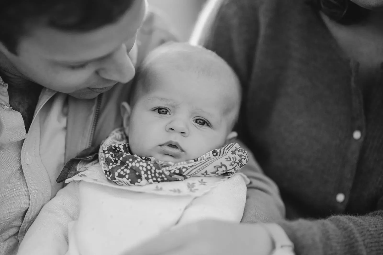 Un père et son nourrisson, en noir et blanc.