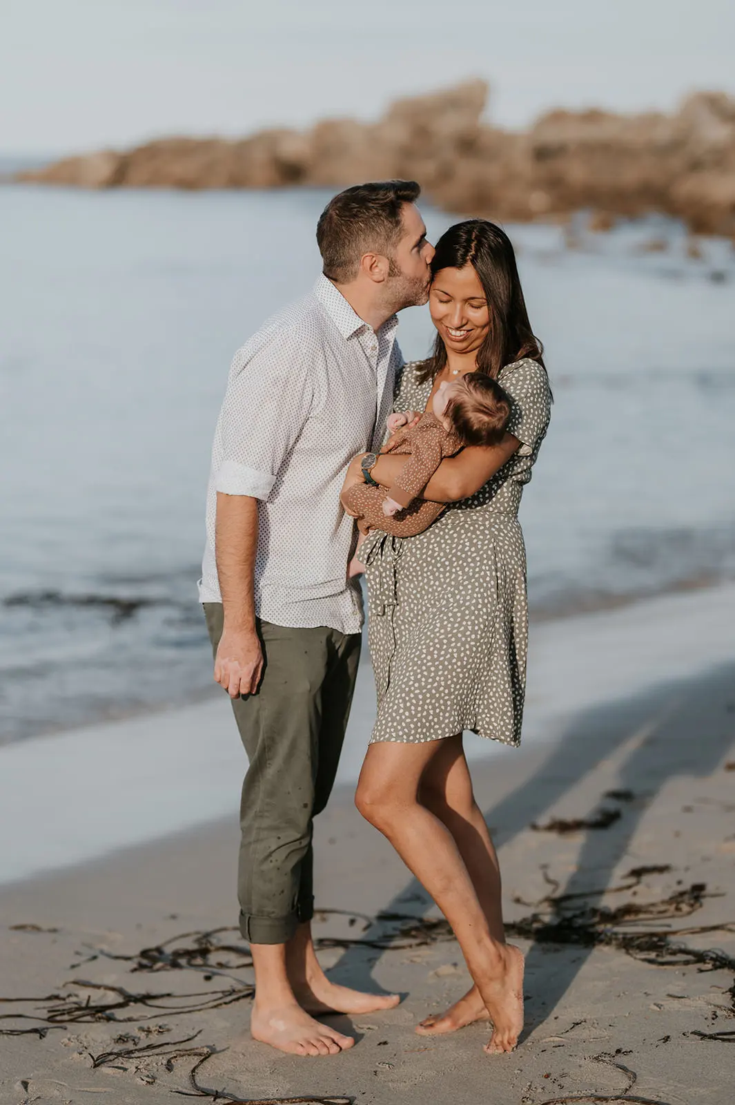 Un couple sur la plage avec son nouveau-né.