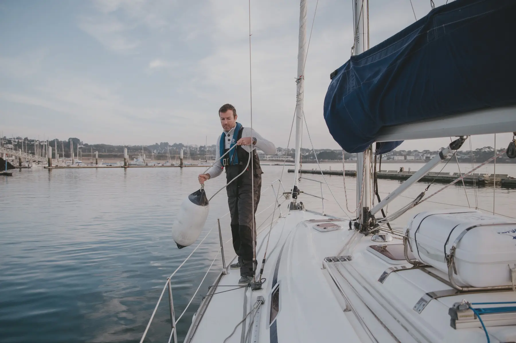 Un homme prépare l’amarrage d’un voilier.
