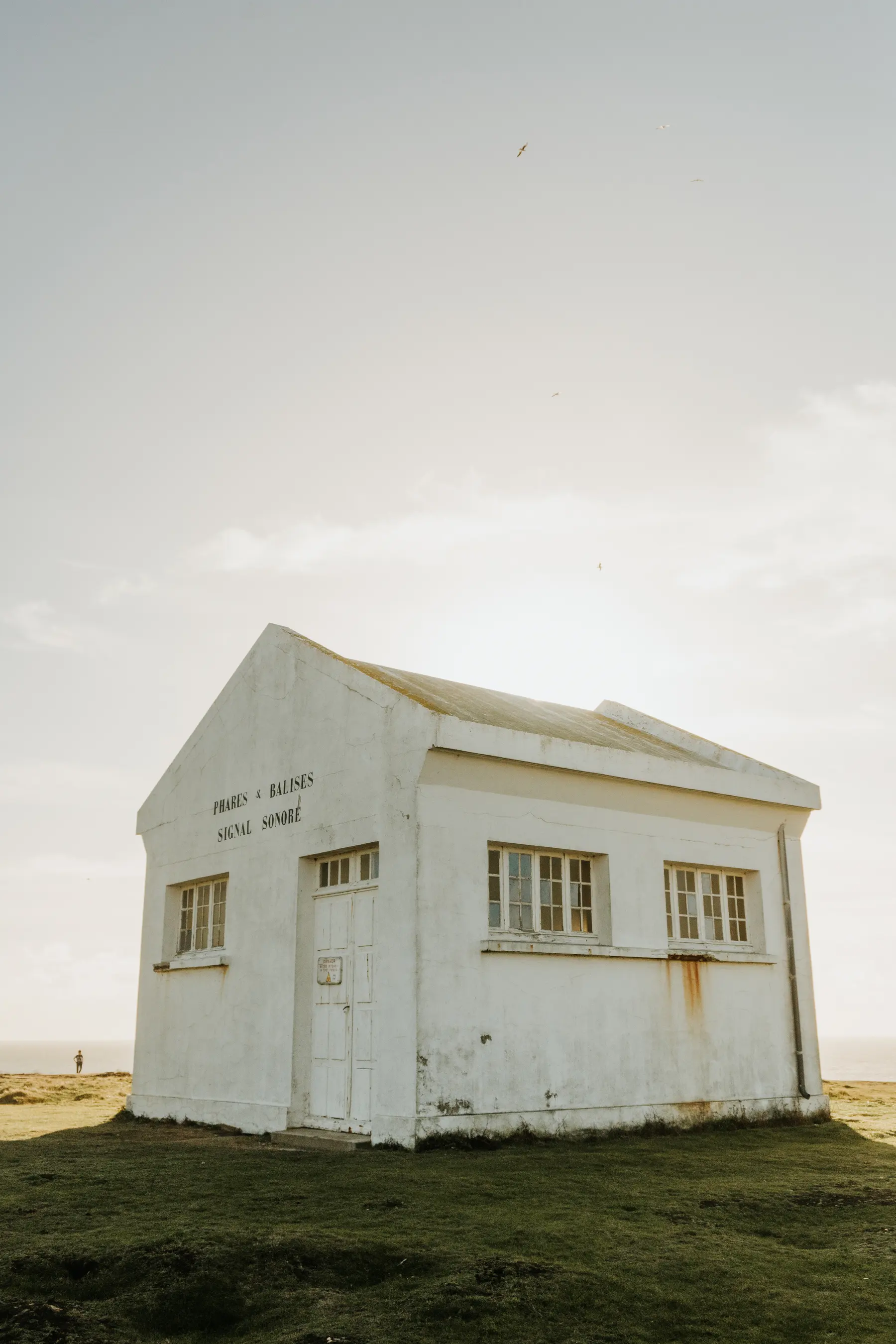 Une maison blanche isolée au milieu de la lande.