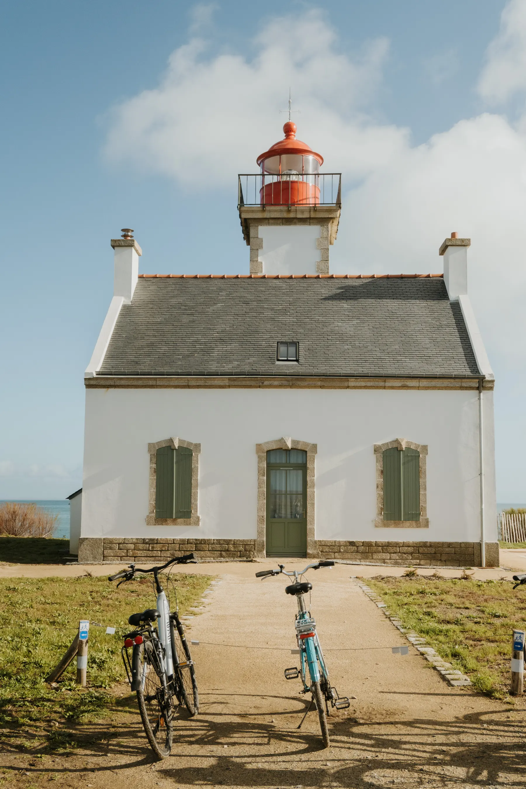 Deux vélos appuyés contre la maison d’un phare.