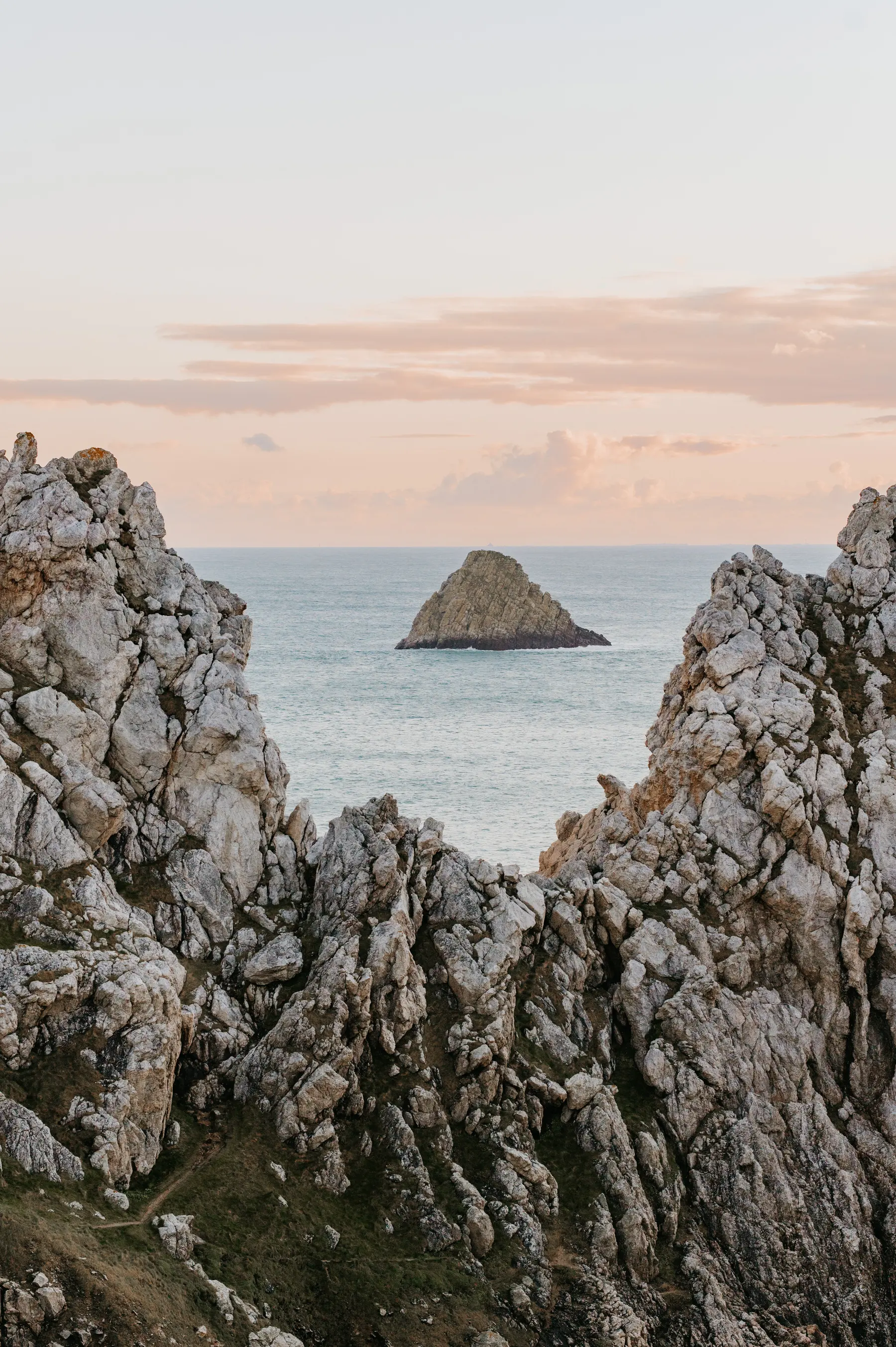 Un îlot rocheux encadré par deux falaises.