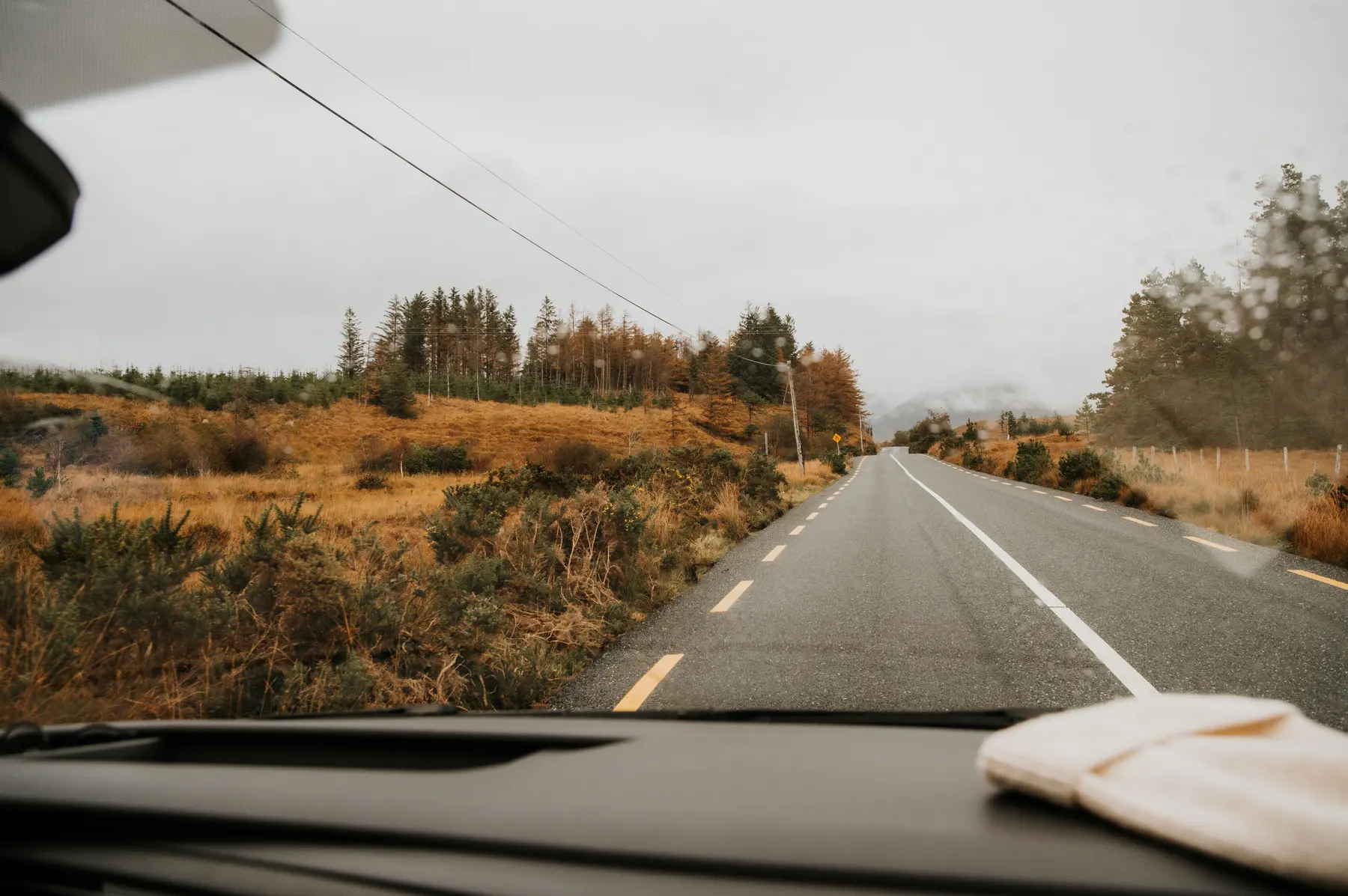 La route défile derrière un pare-brise.